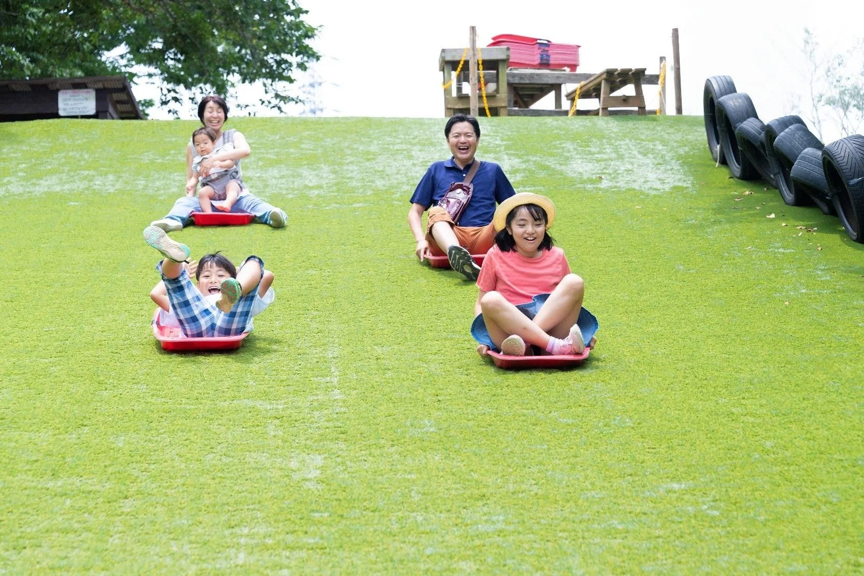 芝生滑りを楽しむ家族