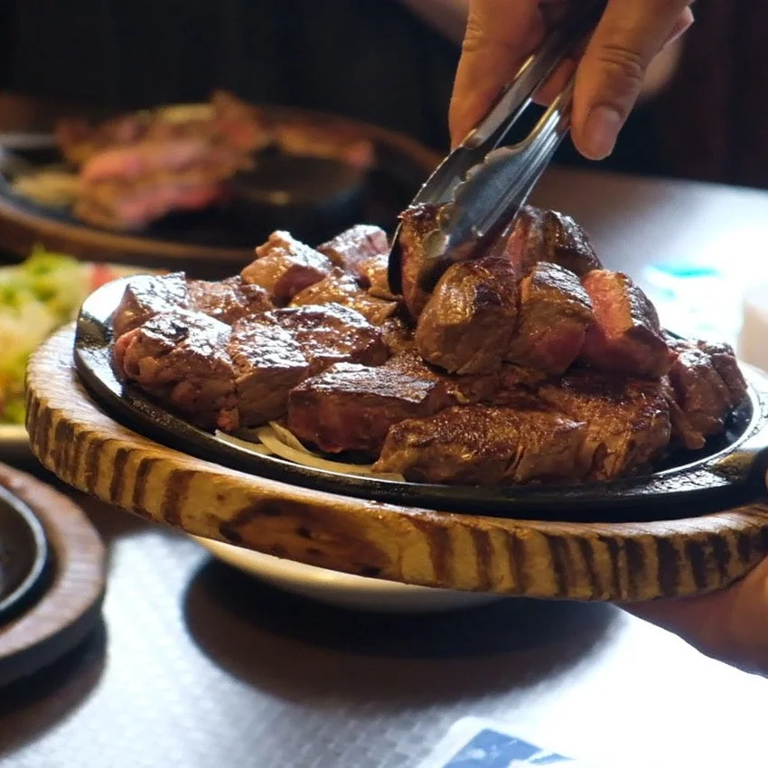 熱々の鉄板に盛られたサイコロステーキ