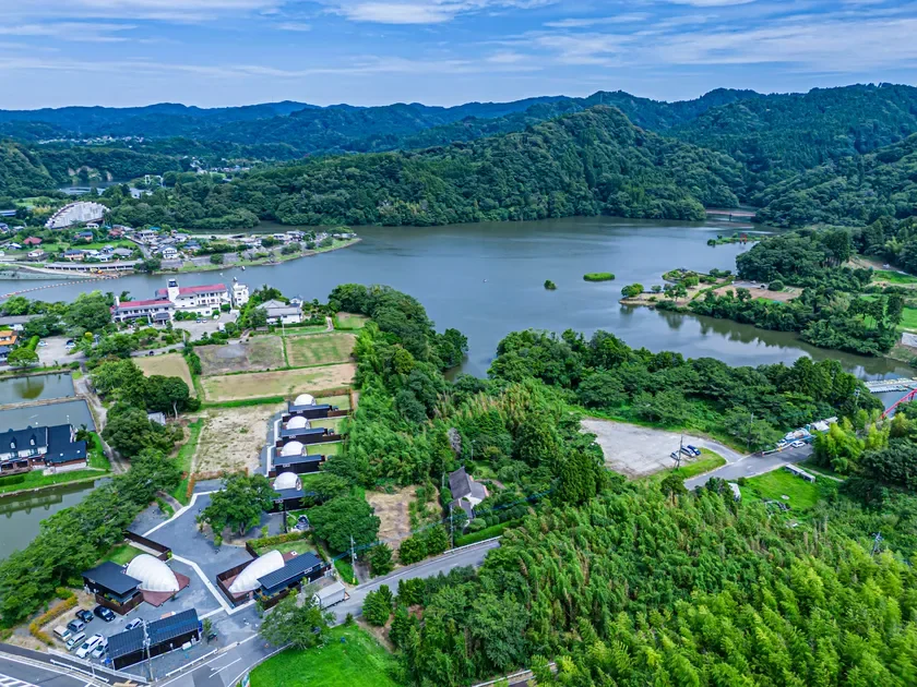 空撮された緑豊かな山々と湖畔