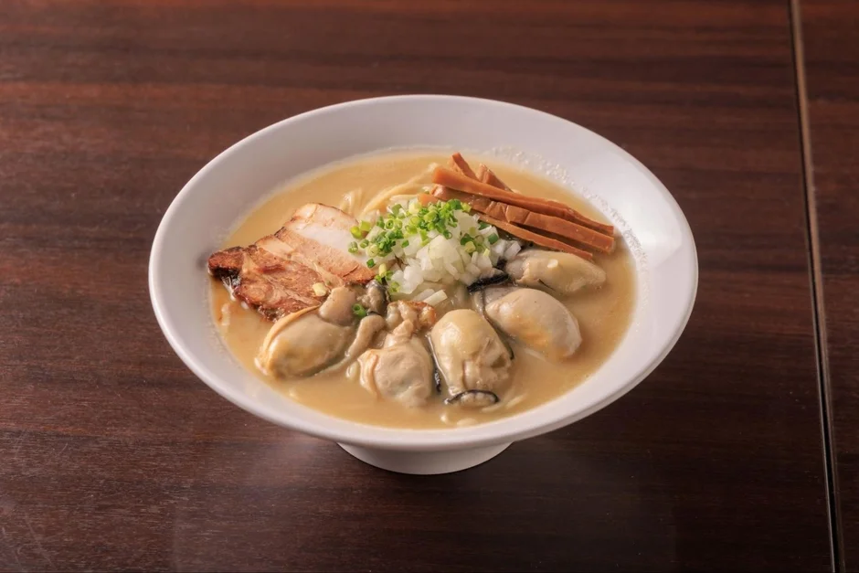 濃厚なスープに新鮮な牡蠣、チャーシュー、刻み玉ねぎなどがトッピングされたラーメン