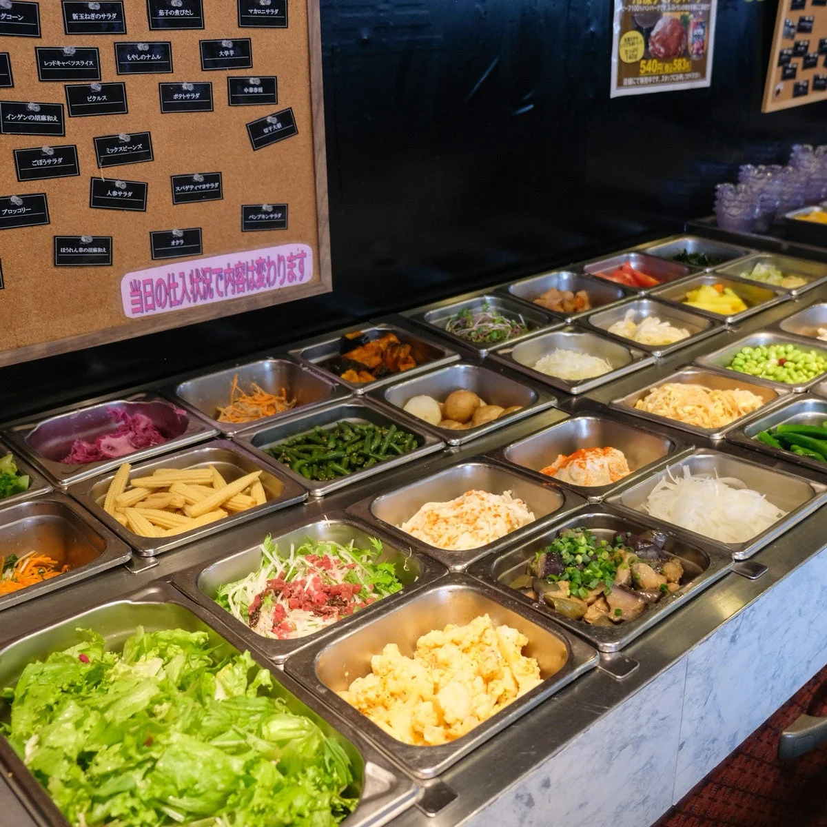 様々な種類のサラダや惣菜が並ぶビュッフェ形式のサラダバーの様子