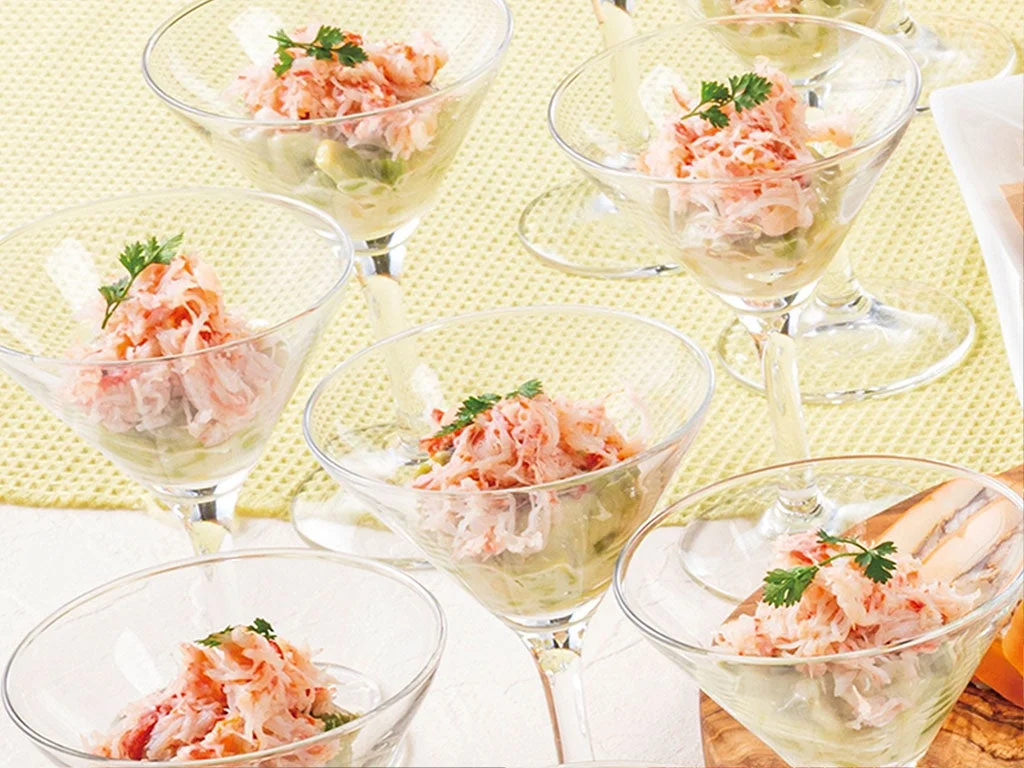 透明なグラスに盛られたカニとアボカドのサラダ