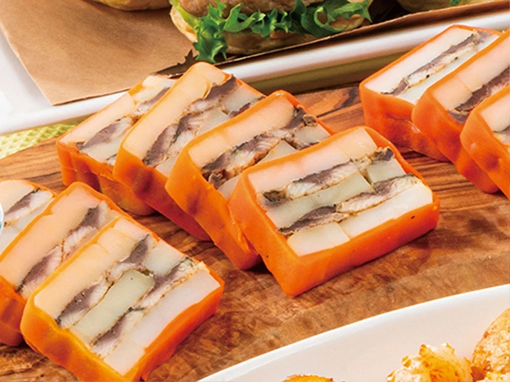 オレンジ色の外側に白い層と魚のような具材が交互に重なったテリーヌ