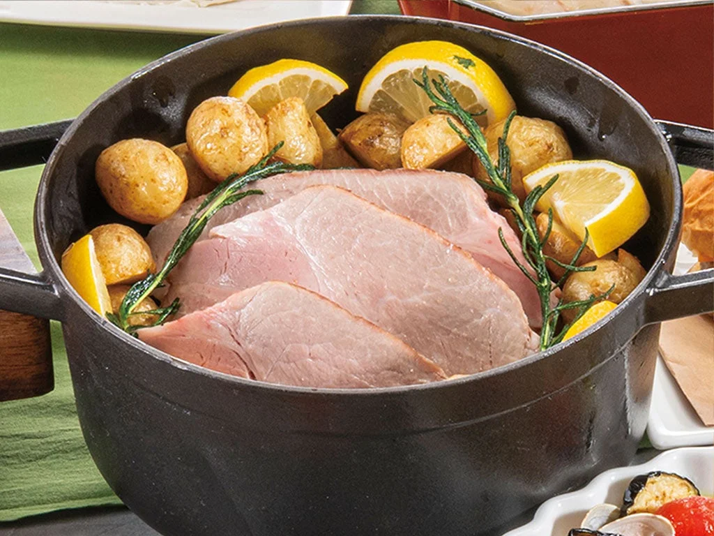 黒い鋳物鍋に、厚切りにされたハムが主役として盛り付けられている